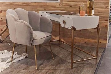 Lifestyle photo of a white desk with bronze metal legs and a curved chair